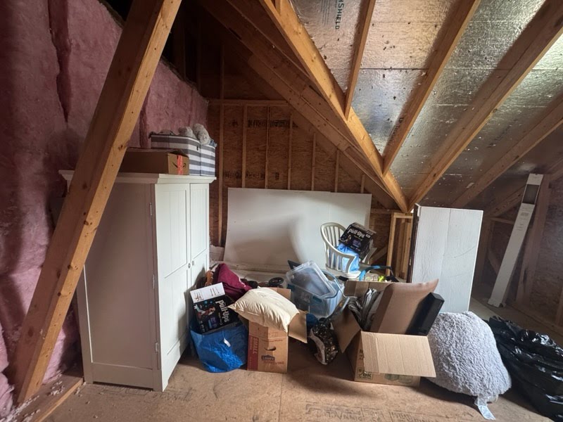 Attic before junk removal with boxes and bags