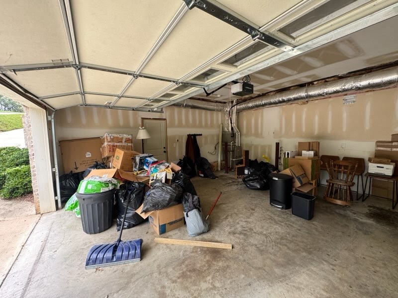 Garage before junk removal with stored items and bags