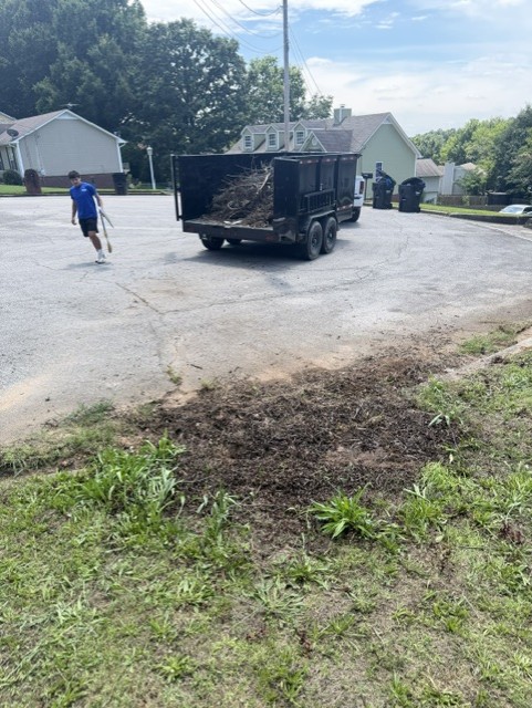 Yard debris after removal with trailer loaded and curb area being cleared